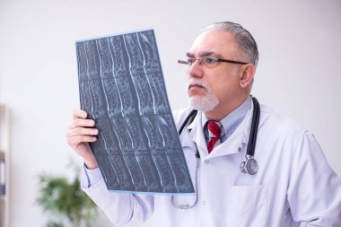 Klinikte çalışan yaşlı bir erkek radyolog.