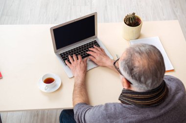 Salgın sırasında evde çalışan yaşlı bir erkek işçi.