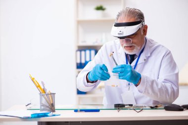 Kanıt için laboratuvarda çalışan yaşlı bir erkek kriminolog.