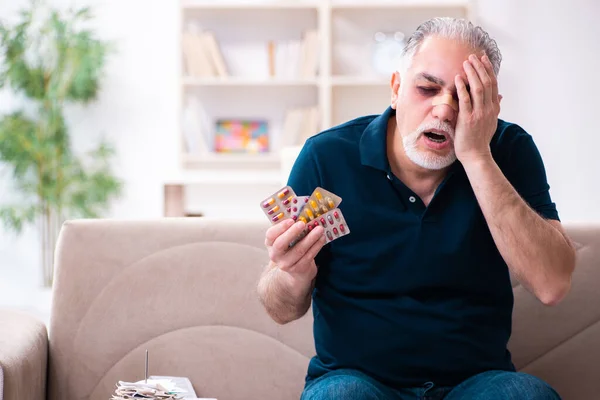 Oude gewonde man in budget planning concept — Stockfoto