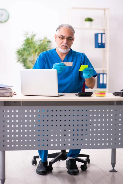 Homem velho médico farmacêutico que trabalha na clínica — Fotografia de Stock