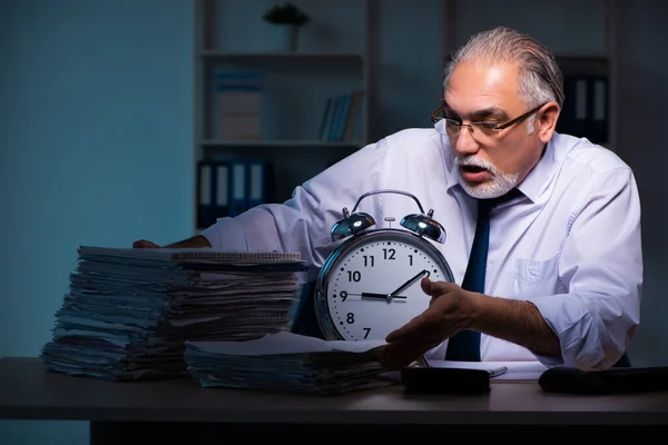 Ancien employé masculin travaillant tard dans le bureau — Photo