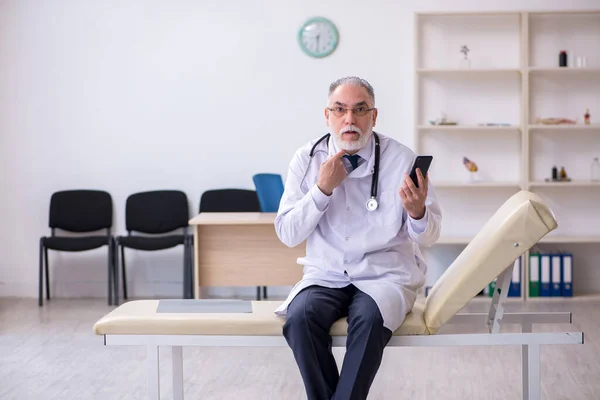 Klinikte çalışan yaşlı erkek doktor. — Stok fotoğraf