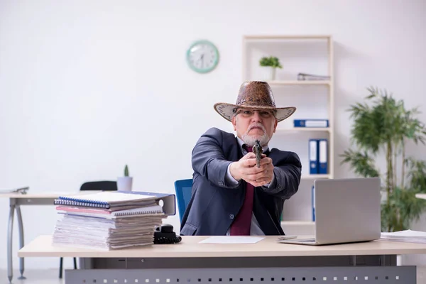 Lustige alte Chefin mit Cowboyhut im Büro — Stockfoto