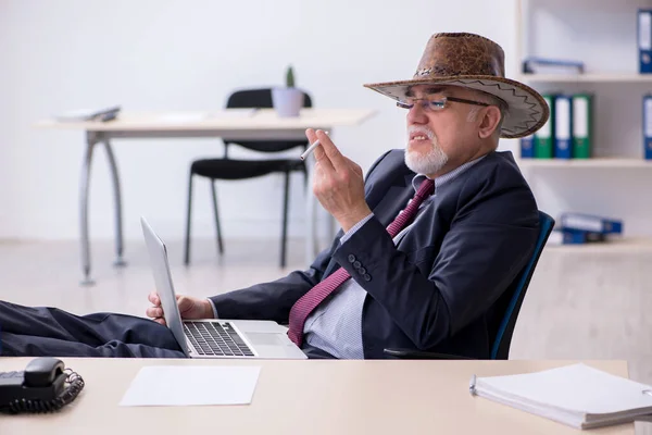 Vicces öreg főnök cowboy kalapban az irodában. — Stock Fotó