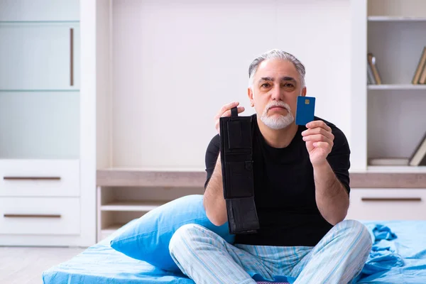 Oude man loopt zonder geld in de slaapkamer — Stockfoto