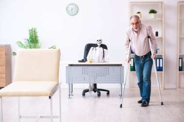 Yaşlı bacağı yaralı bir adam ölü doktoru ziyaret ediyor.