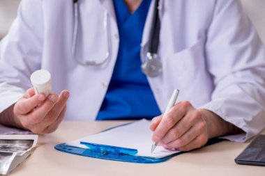 Klinikte çalışan yaşlı bir erkek doktor.