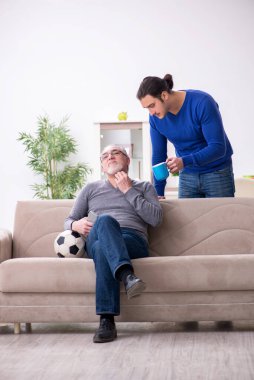Baba oğul televizyonda maç izliyorlar.