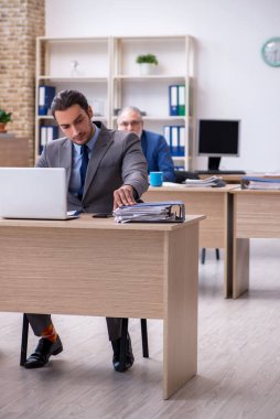 Ofiste çalışan iki erkek çalışan.