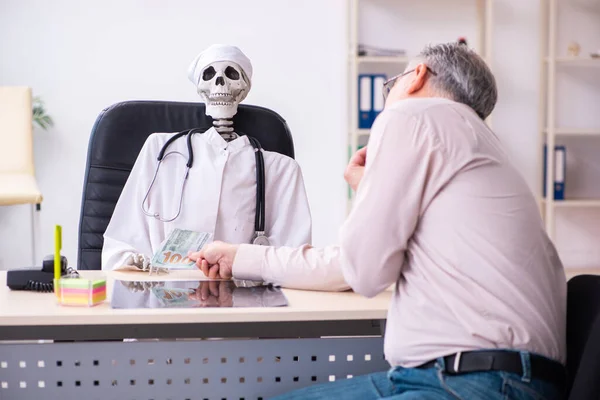 Oude man geeft geld aan dode dokter — Stockfoto