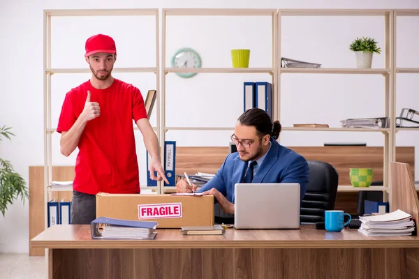 Joven entregando el paquete a la oficina — Foto de Stock