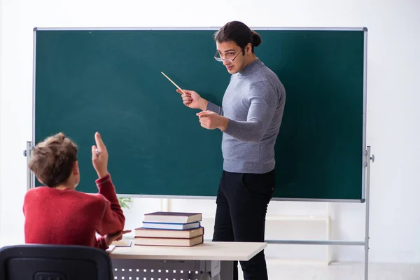 Jonge mannelijke leraar en schooljongen in de klas — Stockfoto