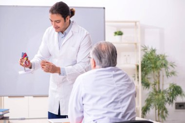 Deneyimli doktor kardiyolog genç erkek asistana