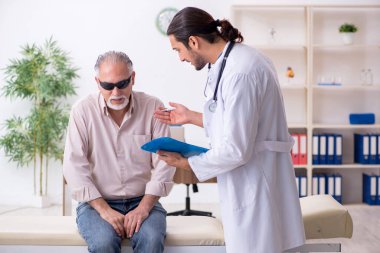 Yaşlı kör adam genç erkek doktoru ziyaret ediyor.