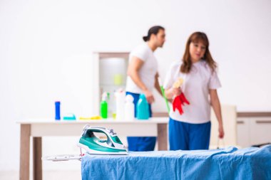 Evde ütü yapan genç bir çift.