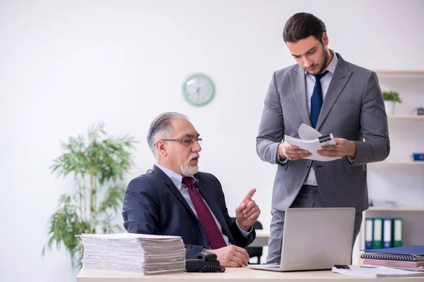 Old boss and his young assistant working in the office — Stock Photo, Image