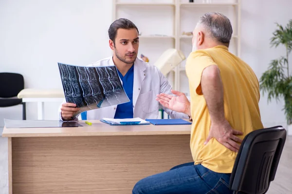 Yaşlı hasta, genç erkek doktor radyolojisti ziyaret ediyor.