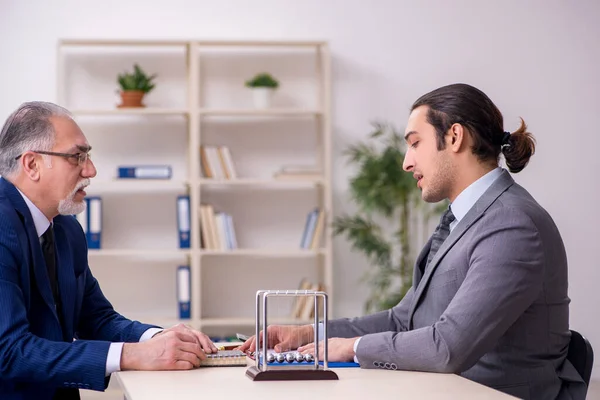 Dois homens de negócios e bolas de meditação na mesa — Fotografia de Stock