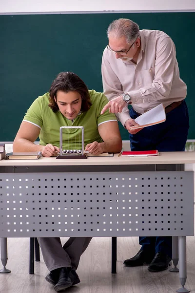 Oude hoogleraar natuurkunde en jonge student in de klas — Stockfoto