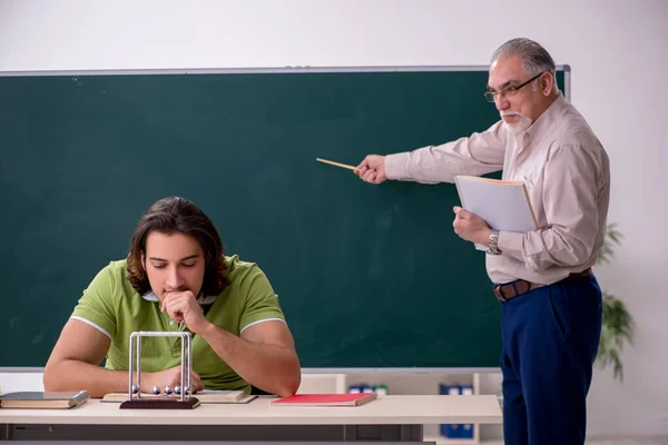 Antiguo profesor físico y joven estudiante en el aula —  Fotos de Stock