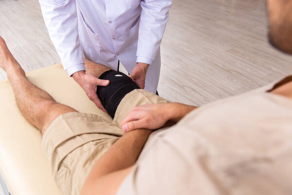 Experienced doctor traumatologist examining young male patient