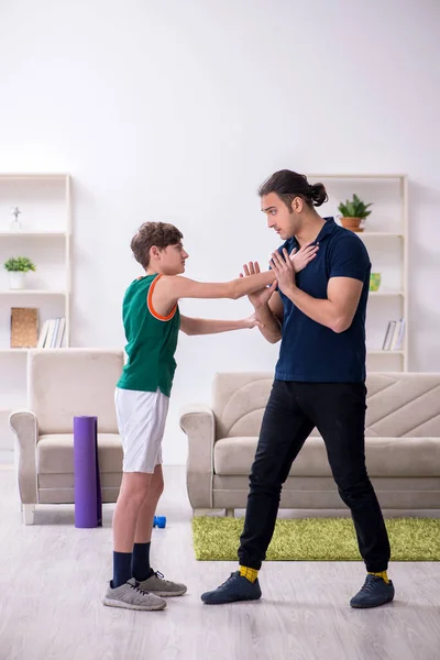 Padre e hijo haciendo ejercicios deportivos en interiores — Foto de Stock