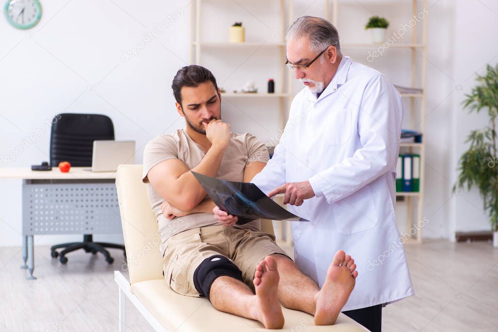 Experienced doctor radiologist examining young male patient