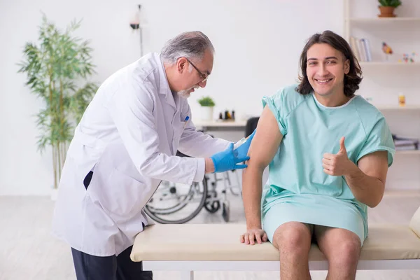 Junge männliche Patientin besucht erfahrenen Arzt — Stockfoto