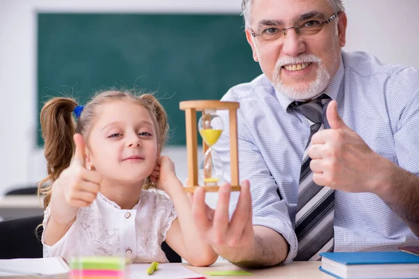 Old teacher and schoolgirl in the school — Stock Photo, Image