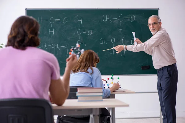 Antigo professor de química e dois alunos em sala de aula — Fotografia de Stock