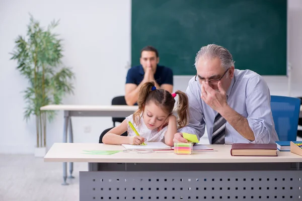 Fiatal szülő, idős férfi tanár és kislány az osztályteremben — Stock Fotó