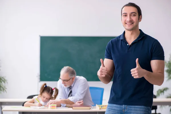 Orang tua muda, guru laki-laki tua dan gadis kecil di kelas — Stok Foto