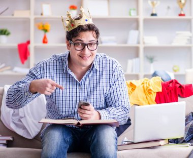 Dağınık odada çalışan genç adam.