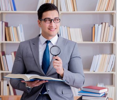 Büyüteçle hukuk fakültesi öğrencisi kitap okuyor.