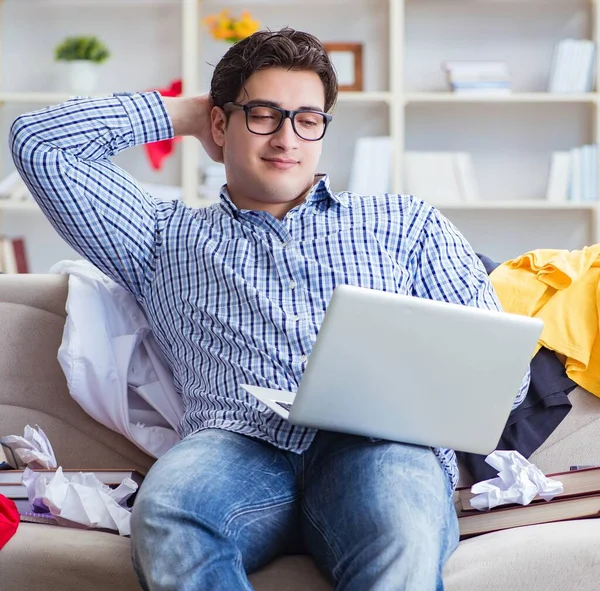 Dağınık odada çalışan genç adam.