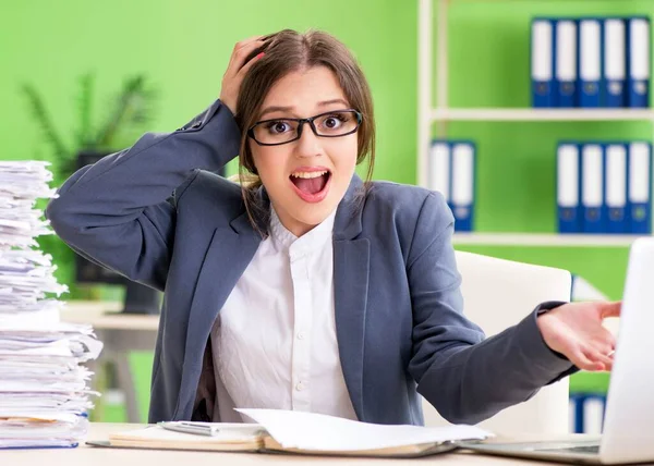 Jonge vrouwelijke werknemer zeer druk met doorlopend papierwerk — Stockfoto