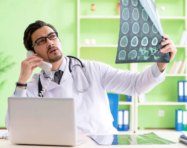 Doktor radyoloji uzmanı hastanede röntgen taramasına bakıyor.