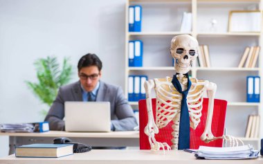 İskeletle çalışan bir iş adamı.