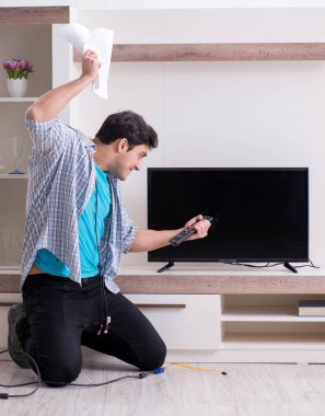 Bozuk televizyonu tamir etmeye çalışan adam