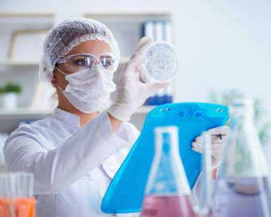 Bir laboratuarda deney yapan kadın bir bilim adamı.