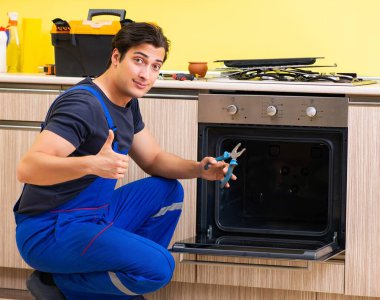 Genç müteahhit mutfak mobilyalarını monte ediyor.