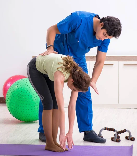 Spor hocası egzersiz sırasında sporcuya yardım ediyor.