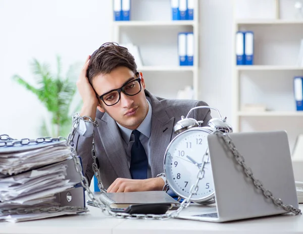 Ofis masasına zincirlenmiş meşgul bir çalışan.