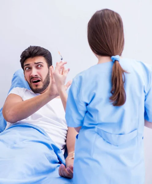 Женщина-врач осматривает пациента-мужчину в больнице — стоковое фото