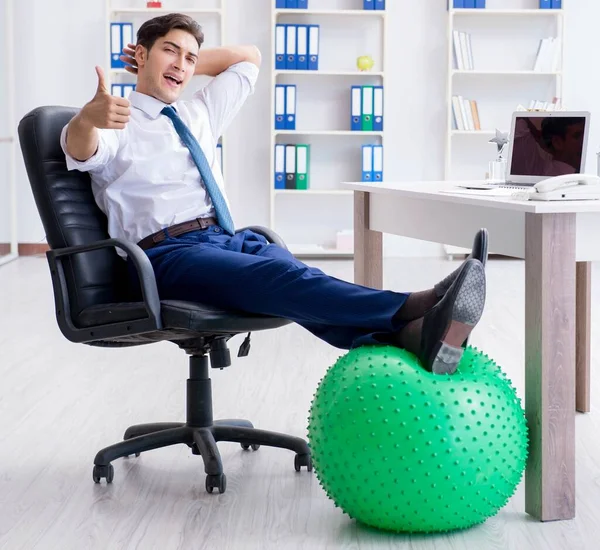 Young businessman doing sports stretching at workplace — Stock Photo, Image