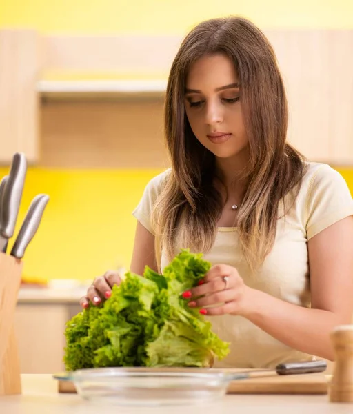 Fiatal nő készít salátát otthon a konyhában — Stock Fotó