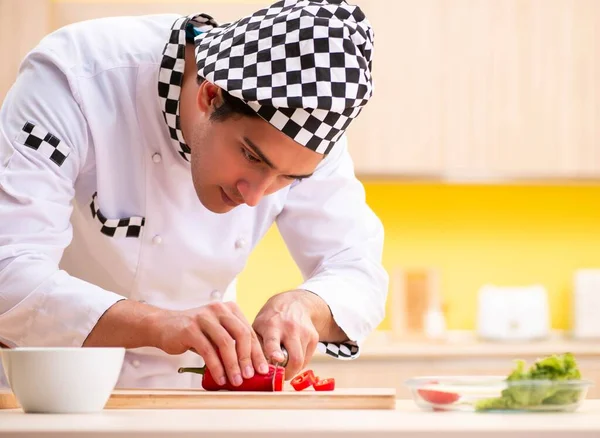 Joven cocinero profesional preparando ensalada en casa — Foto de Stock