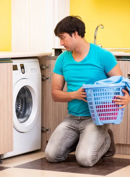 Jeune mari homme faisant la lessive à la maison — Photo