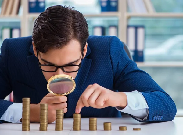 Empresário com pilhas de moedas no escritório — Fotografia de Stock